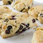 Blueberry Scones - Light, tender, slightly sweet and tangy! This blueberry scone recipe rivals any bakery scone you've ever eaten. Buttery rich and popping with sweet and tangy blueberries!