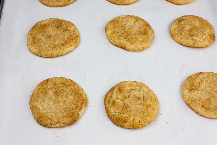 Baked snickerdoodle cookies on the baking sheet.