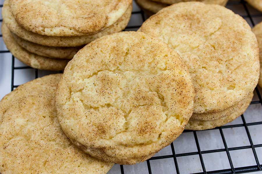 Baked chewy snickerdoodle cookies on a wire rack.