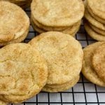 Best chewy snickerdoodle cookies stacked on a wire cooling rack.