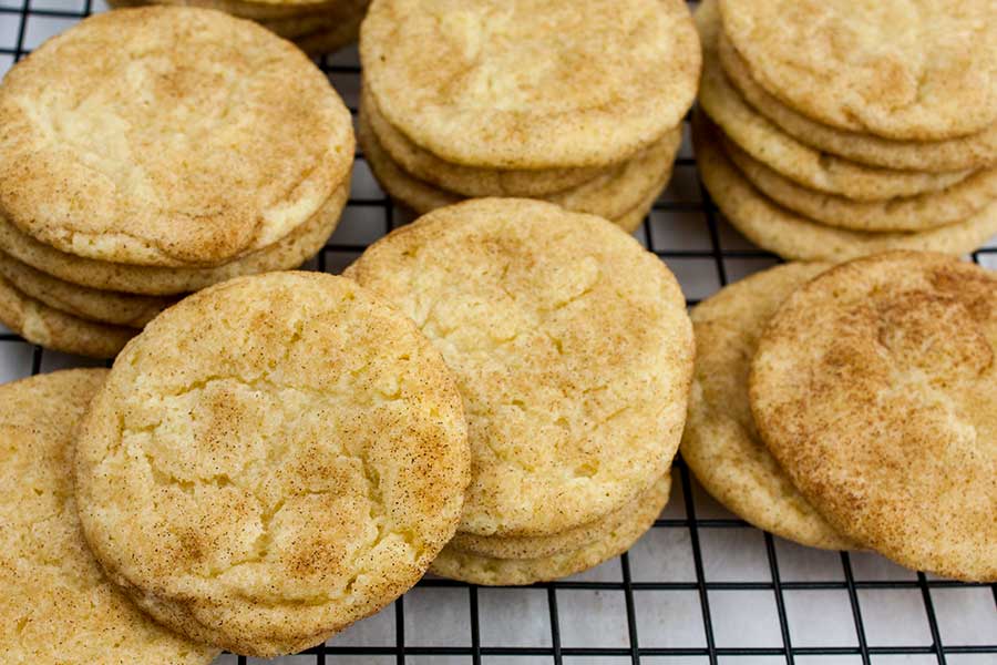 Best chewy snickerdoodle cookies stacked on a wire cooling rack.