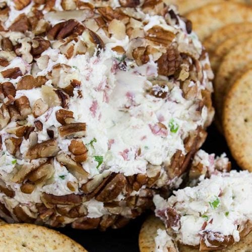 Pecan crusted cheese ball surrounded in crackers.