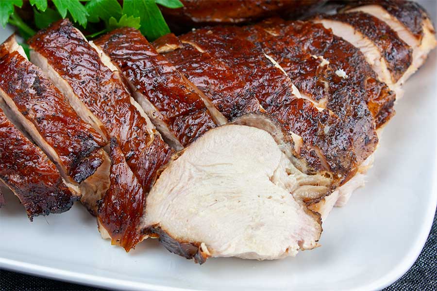 Smoked Turkey Breast - Blow your friends and family away with this very easy, moist and tender, flavorful turkey breast. sliced smoked turkey breast on a white platter
