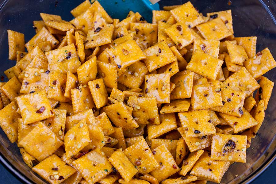 Firecracker Cheez-Itz - crackers in a large glass bowl with seasoning mixture poured over