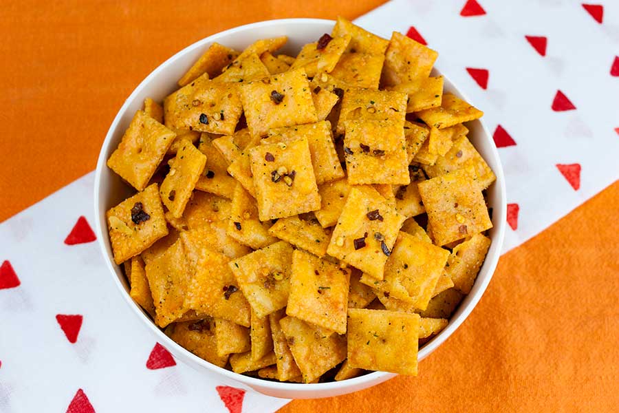 Firecracker Cheez-Itz in a white bowl on an orange table cloth.