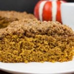 A slice of pumpkin coffee cake with streusel topping on a white plate.