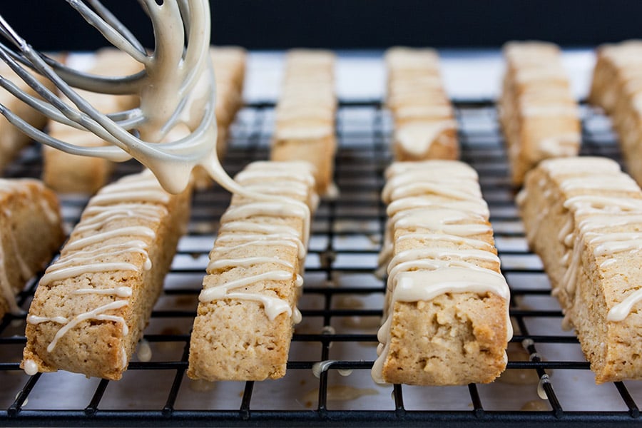 Spiced Apple Cider Biscotti - glaze being drizzled over baked biscotti