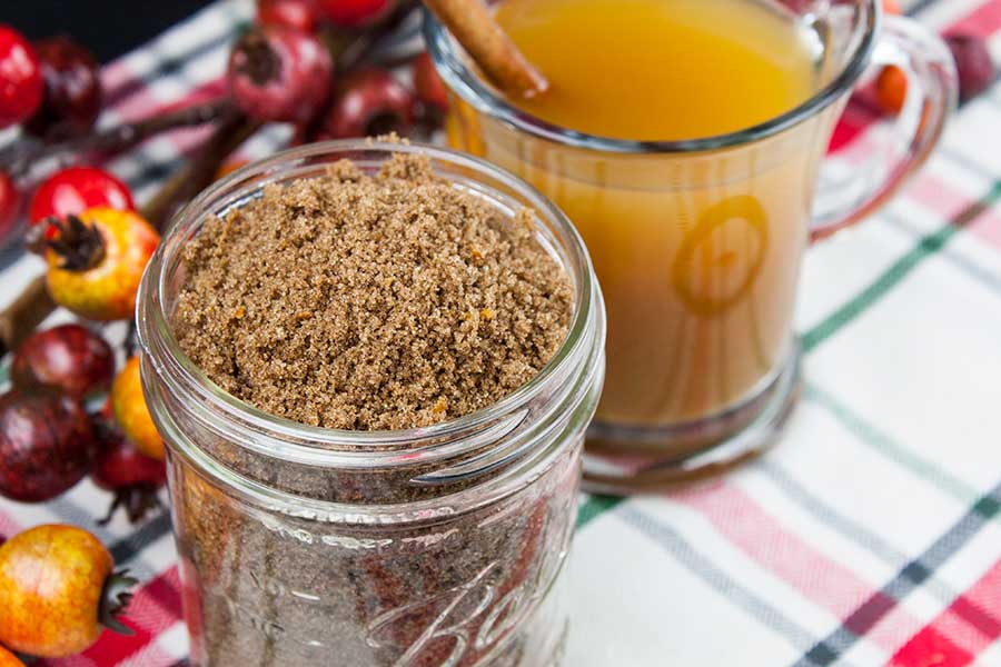 Apple Cider Spice Mix - closeup of the spice mix in a mason jar with a glass mug of hot apple cider next to it