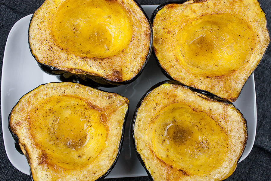 Roasted acorn squash on a white platter.