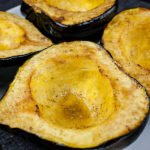 Roasted acorn squash halves on a white platter.