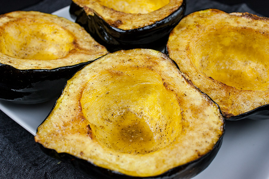 Roasted acorn squash halves on a white platter.