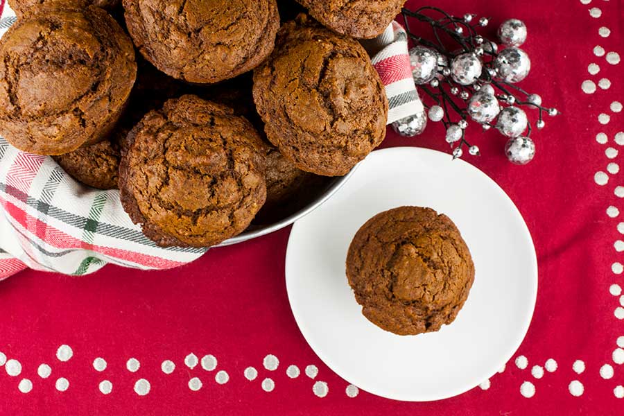 Gingerbread muffins in a basket lined with red, white, and green towel.