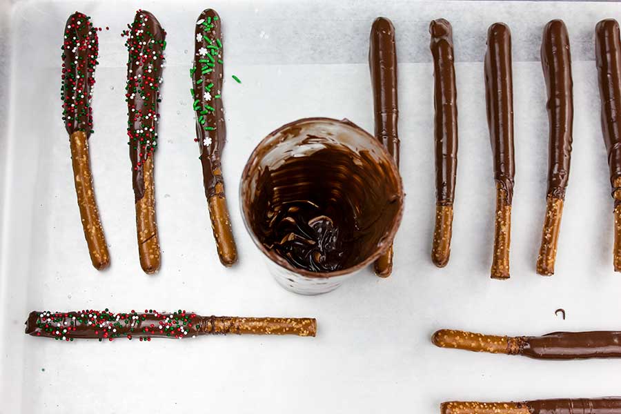 Dark Chocolate Covered Pretzel Rods on a parchment paper baking sheet.