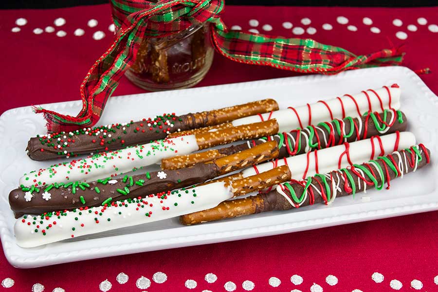 Chocolate Covered Pretzel Rods - choclated dipped and decorated pretzel rods placed on a white plate