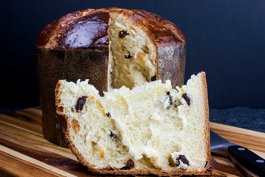 Panettone bread slice on wooden board.