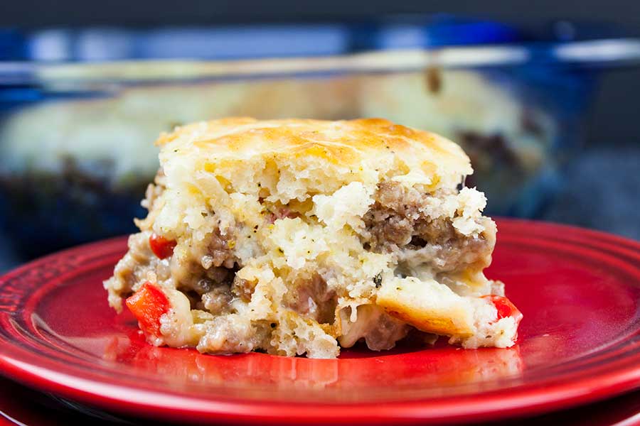 Sausage breakfast cake on a red plate.