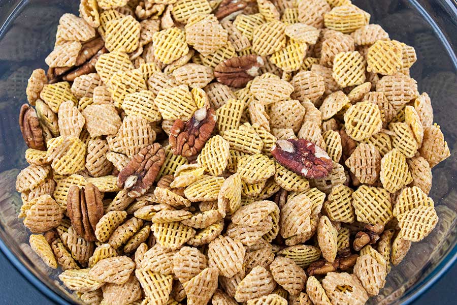 Crispix cereal and pecans in a glass bowl