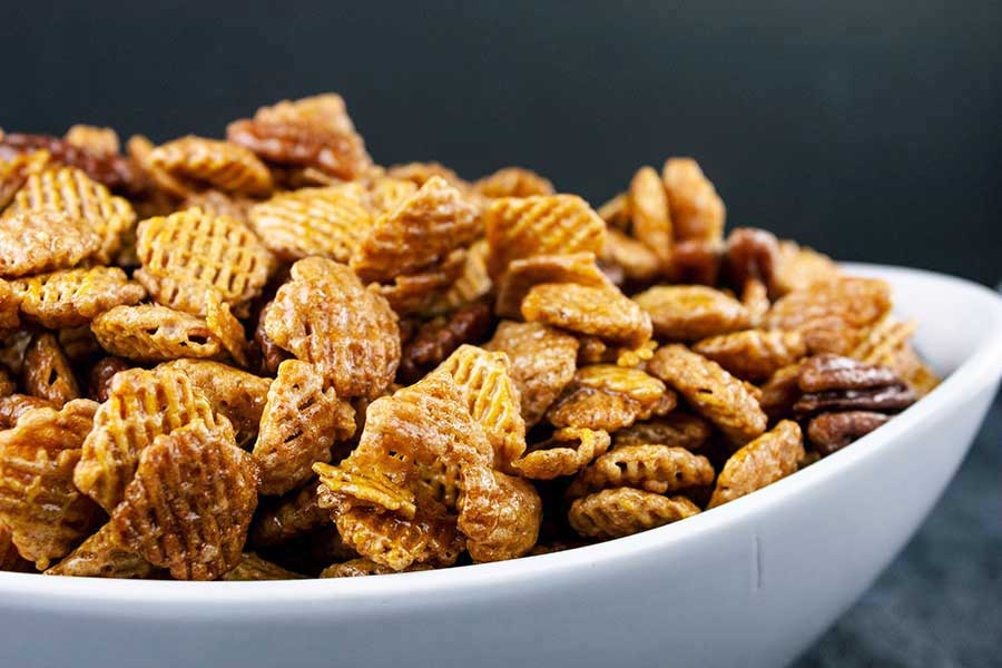 closeup of the Praline Crunch Snack Mix in a white serving bowl