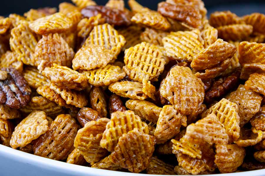 closeup of the Praline Crunch Snack Mix in a white serving bowl