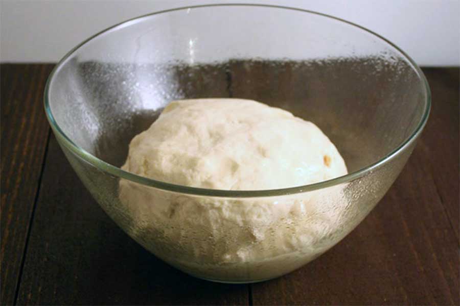 Dough in a glass bowl.