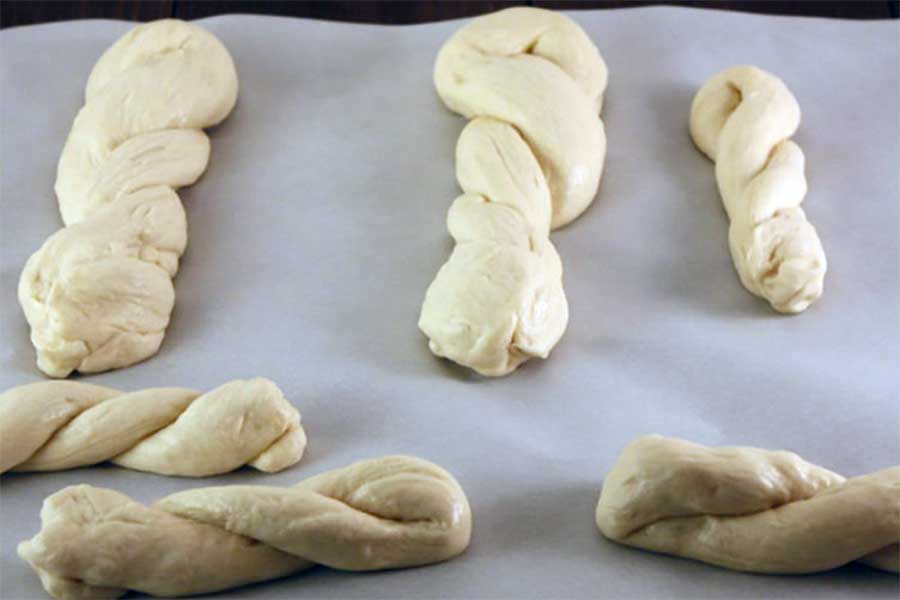 Shaped pretzel dough on parchment paper.