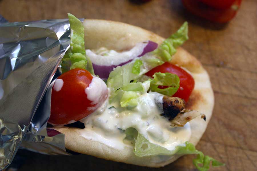 Chicken gyro on a wooden board.