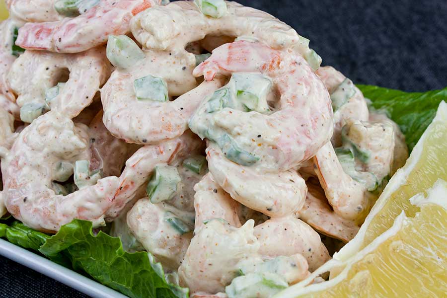 Shrimp Salad over lettuce leaves in a white bowl.