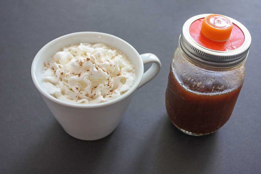 Pumpkin spice latte in a white coffee mug topped with whipped cream.