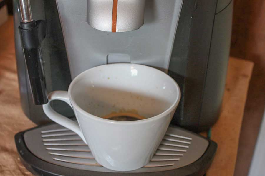 Espresso being pulled into a white cup.