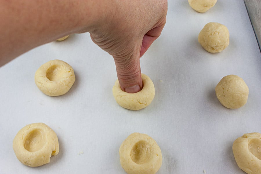 showing using your thumb to indent the cookie dough balls