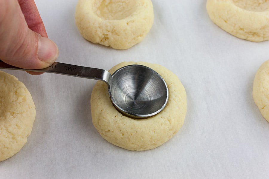 using a teaspoon measure to reform the indentations on the cookies