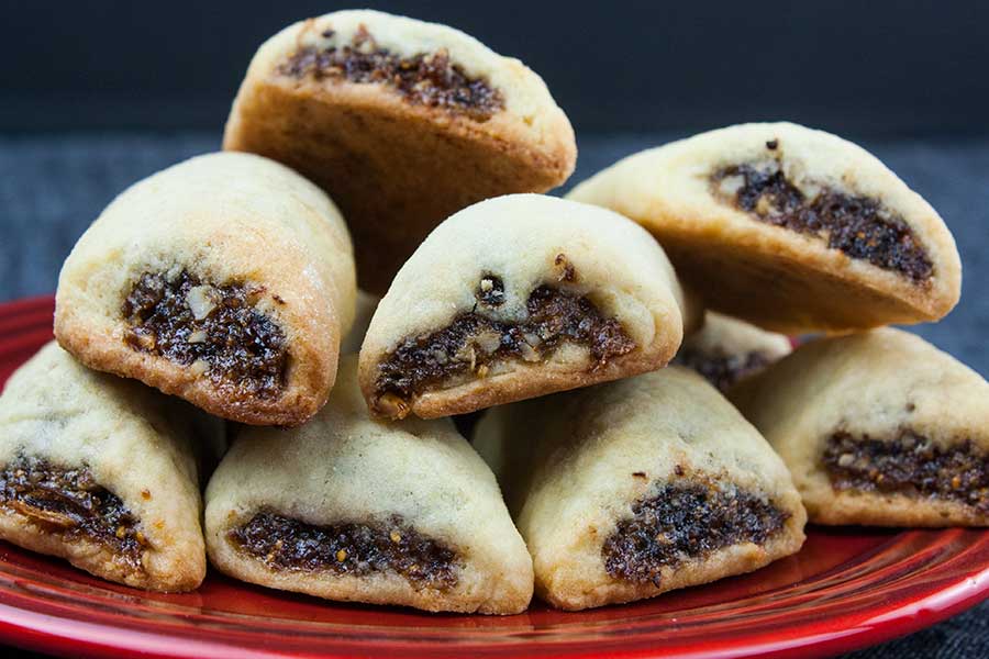 Italian fig cookies, or Cucidati, stacked on a red plate.