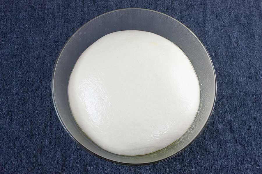 Dough in a glass bowl.
