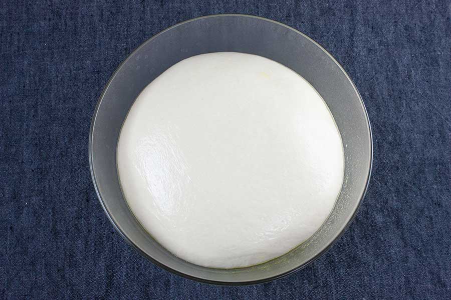 Dough in a glass bowl.