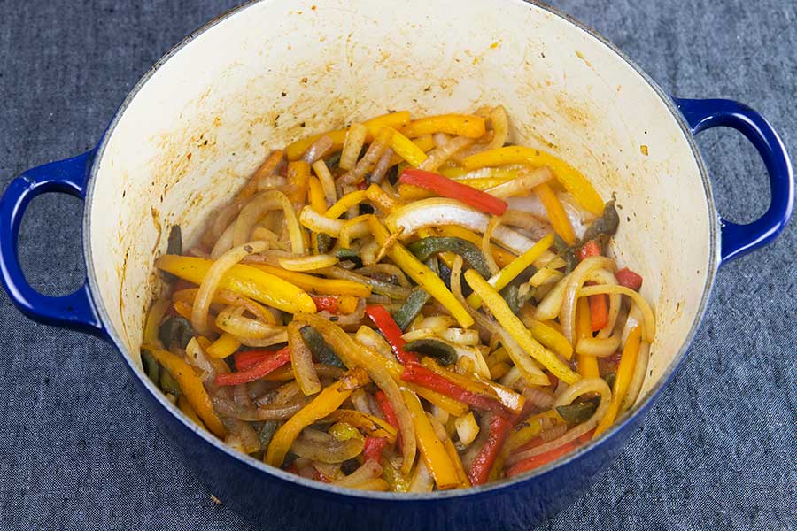 Caramelized peppers in a blue dutch oven.