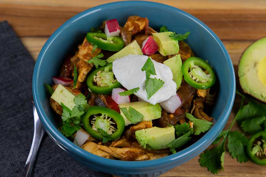 A blue bowl of chicken fajita stew.