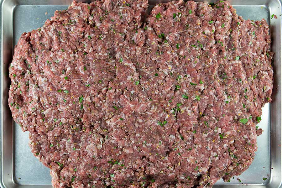 Mixed Italian sausage on a baking sheet.