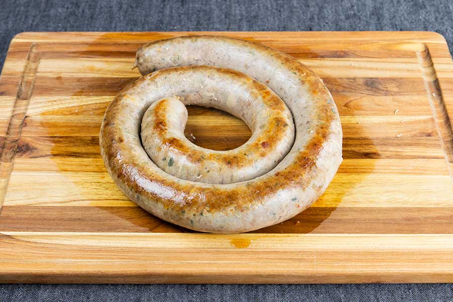 Italian sausage on a cutting board.