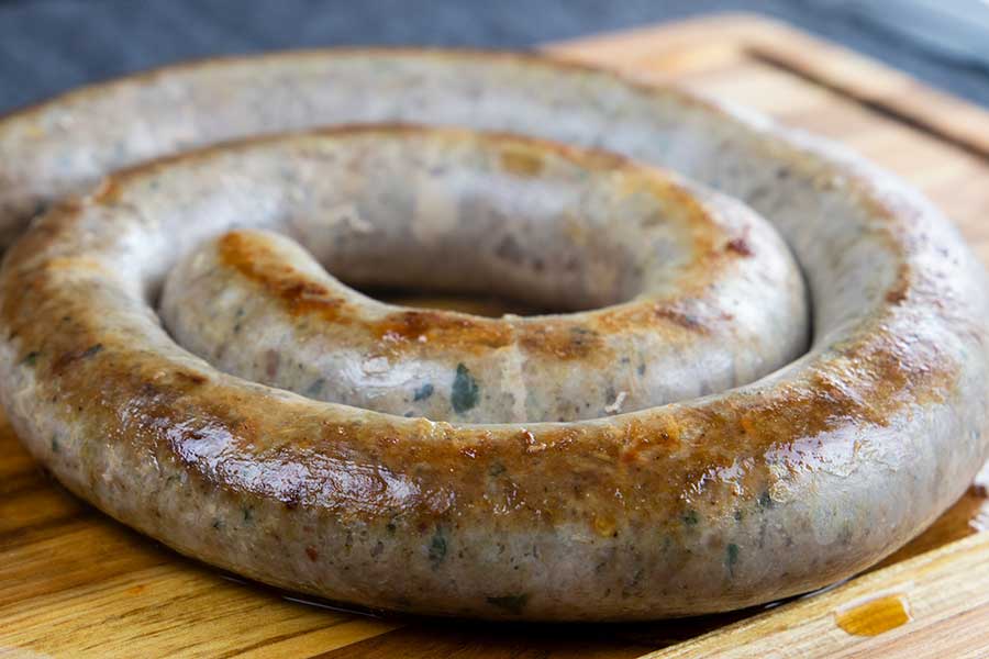 Cooked homemade Italian Sausage ring on a wooden cutting board.