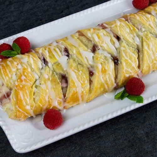 Raspberry Cream Cheese Danish - finished danish on a white platter garnished with raspberries and mint