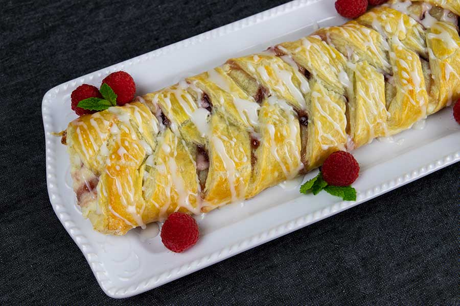Raspberry Cream Cheese Danish - finished danish on a white platter garnished with raspberries and mint