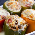 A close up of stuffed bell peppers with melted cheese on top.