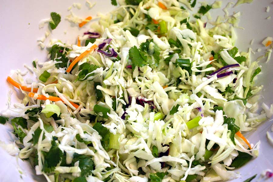 Cilantro slaw mix in a white bowl.