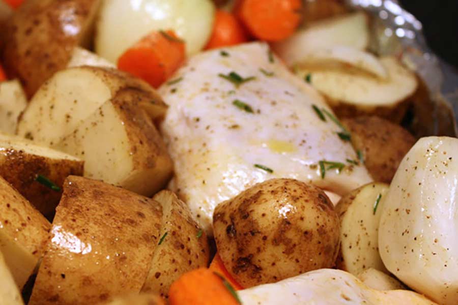 One Pan Roasted Chicken and Vegetables - Super easy and incredibly delicious meal all in one pan! Perfect for meal prep. Raw vegetables and chicken rubbed with oil and seasonings.