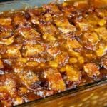 Baked Beans topped with bacon in a glass baking dish.