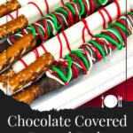 Chocolate covered pretzel rods on a light colored oblong plate.
