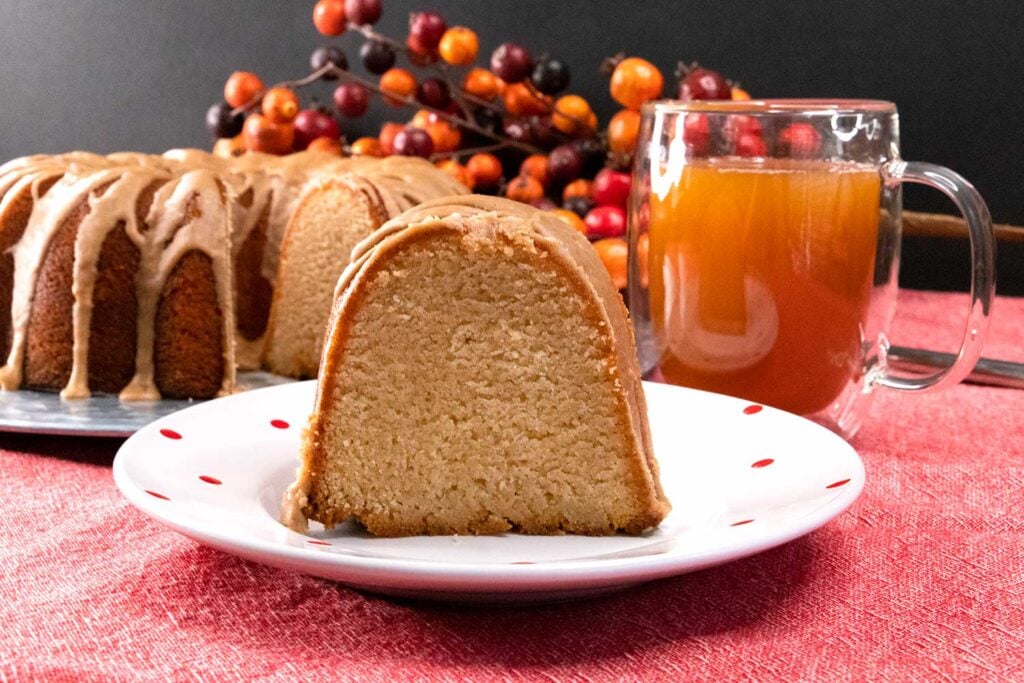 slice of apple cider pound cake on white plate with red dots