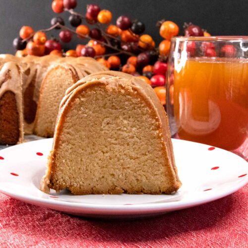 slice of apple cider pound cake on white plate with red dots