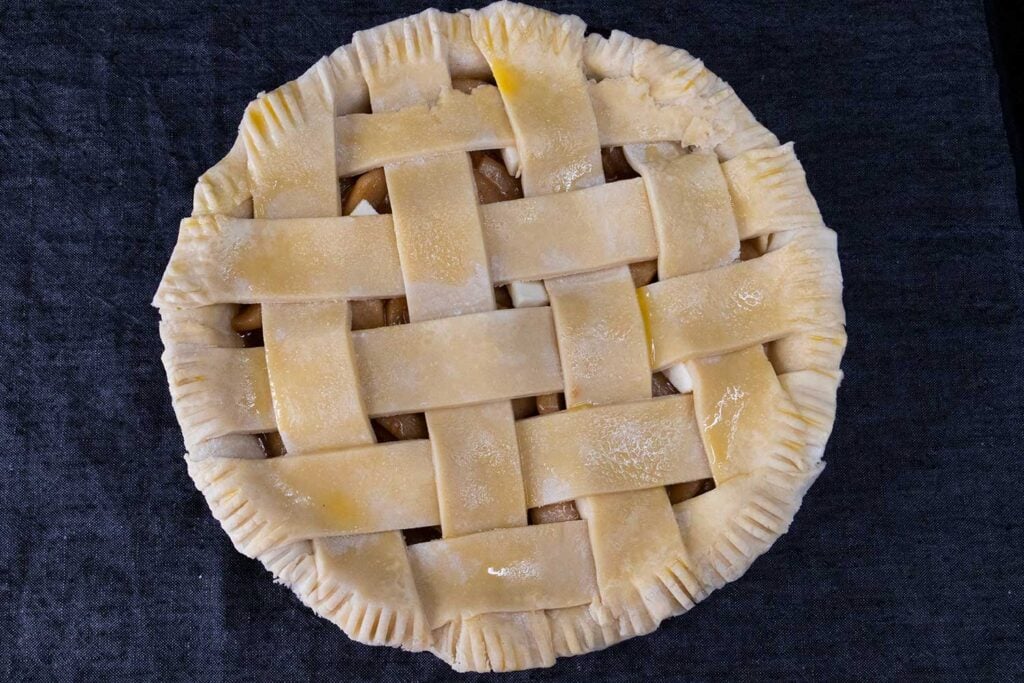 lattice pie crust on an uncooked apple pie.