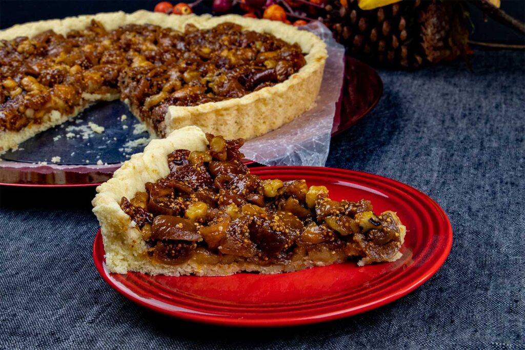 A slice of fig tart on red plate.